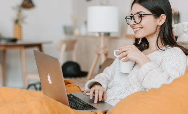 Hubspot CRM. Agencia Cebra. Onboarding. Imagen de mujer sentada con un notebook y una taza en su mano.